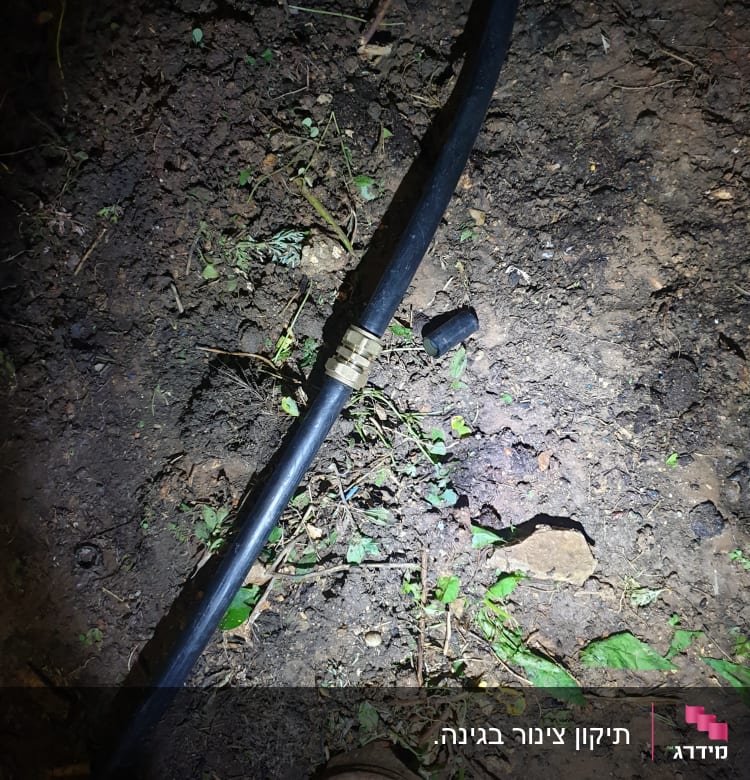 צינור שחור עם מחבר מתכת על אדמה